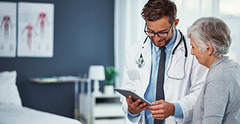 A doctor showing a patient information on his tablet