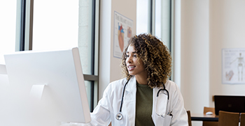 A doctor in her office looking at her computer screen