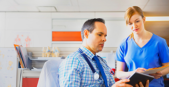 A doctor and a nurse speaking to eachother