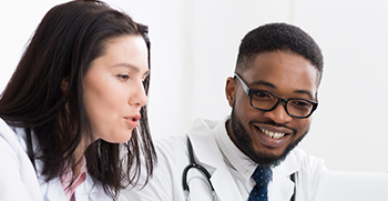 Two doctors sitting next to each other and conversing
