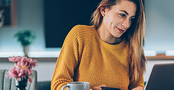 A woman looking at her computer and paying online