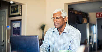 A man looking at his computer at home