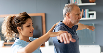 A sports medicine professional testing balance for an elderly patient